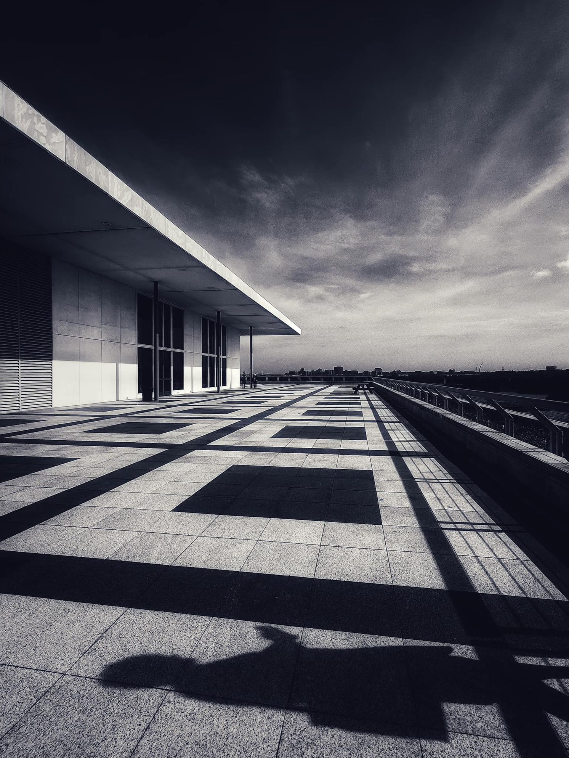 A photographer's shadow on a sunlit terrace