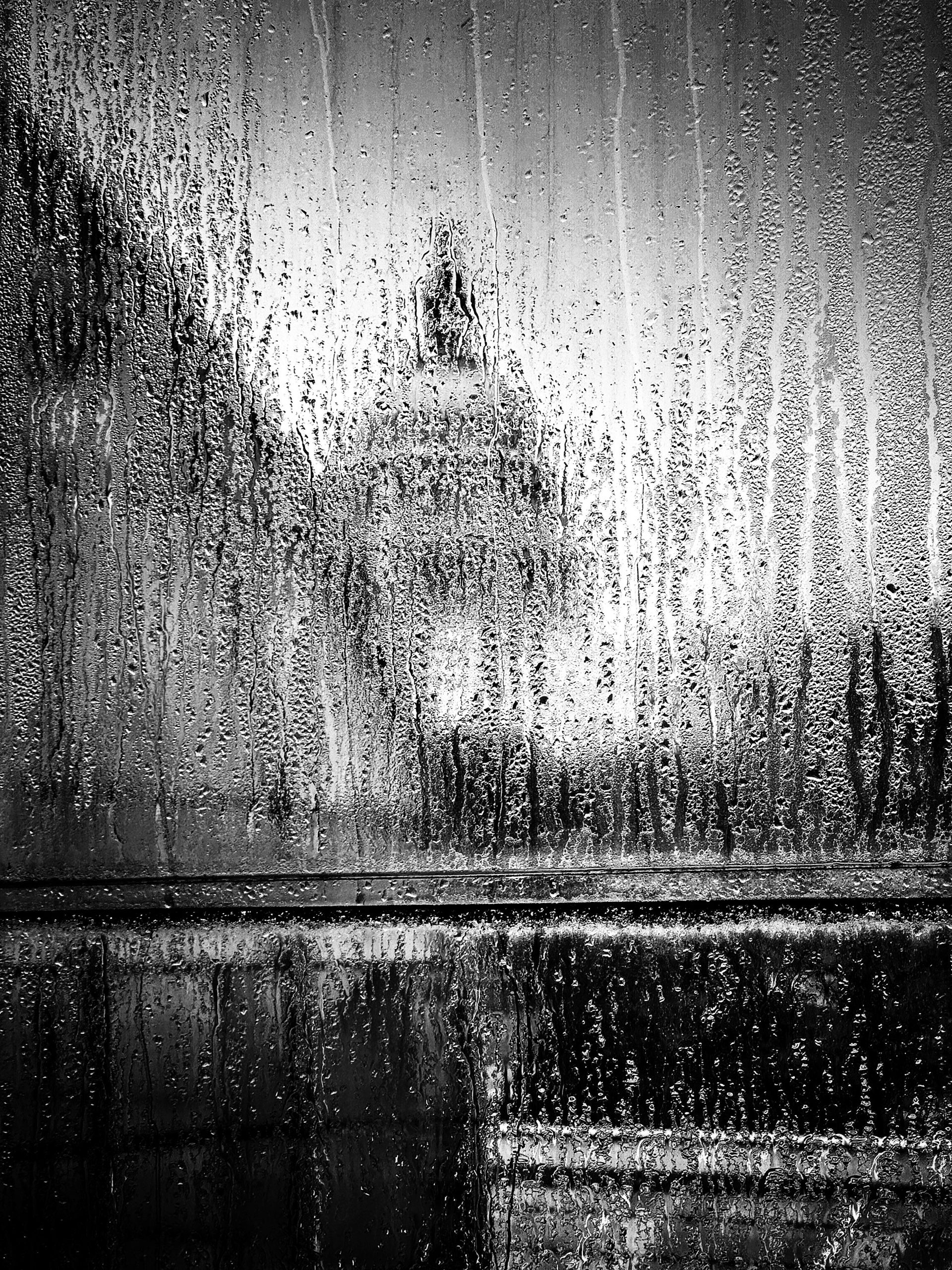A capitol dome seen through a rain-streaked window