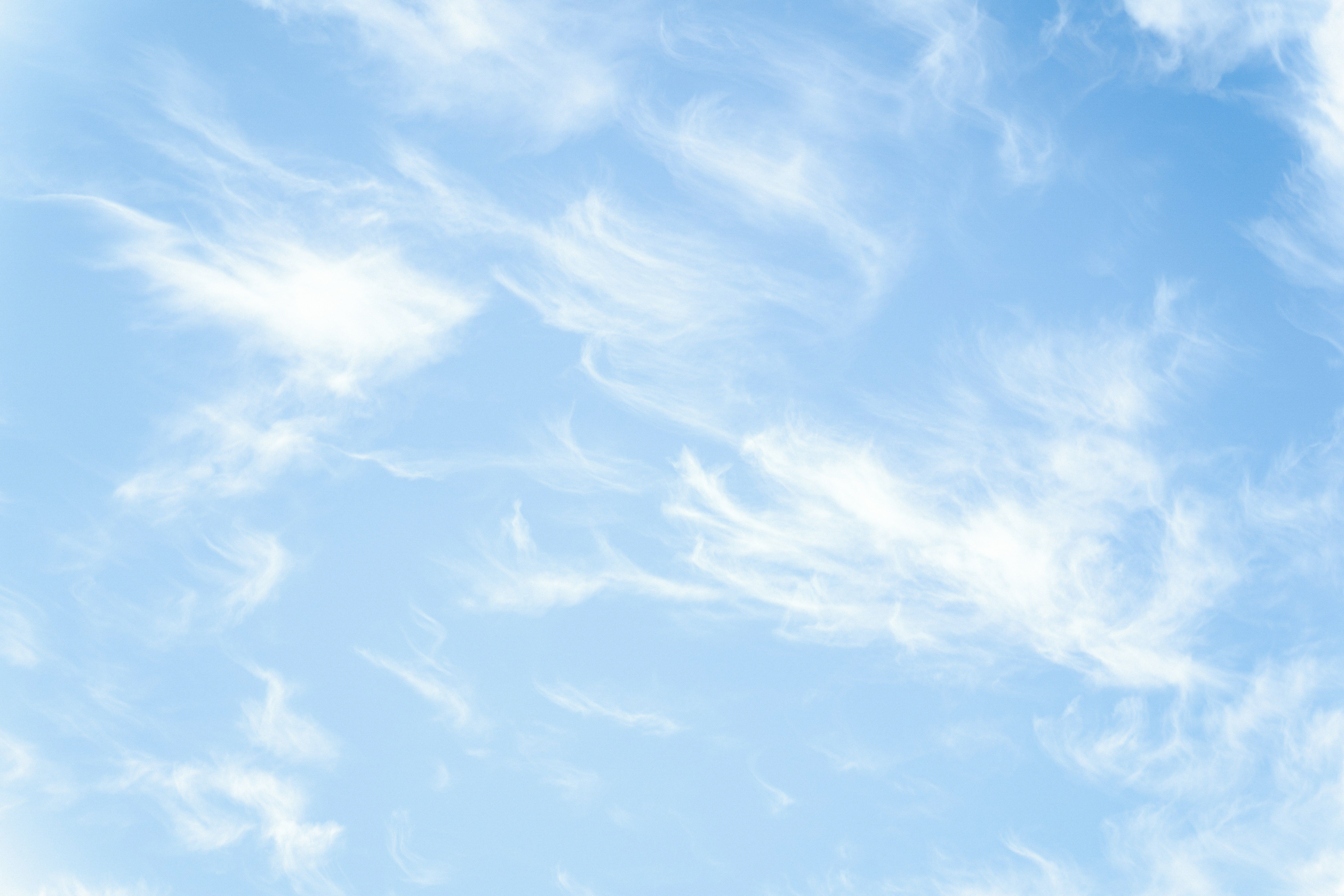 Wispy cirrus clouds across a soft blue sky