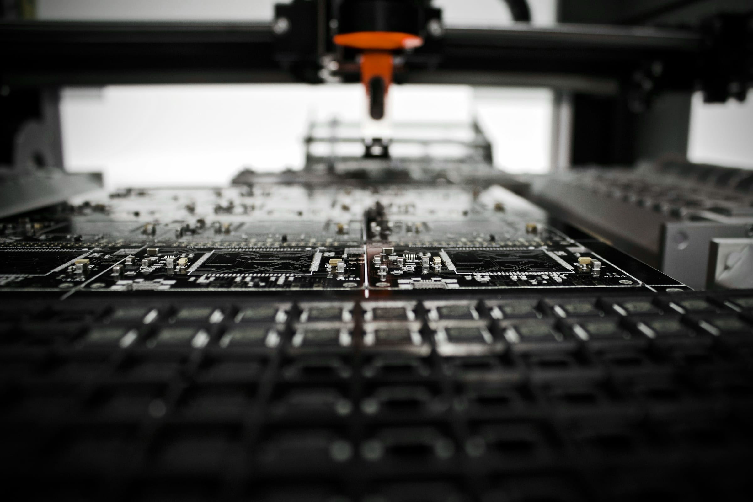 PCB assembly line with orange SMT placement head
